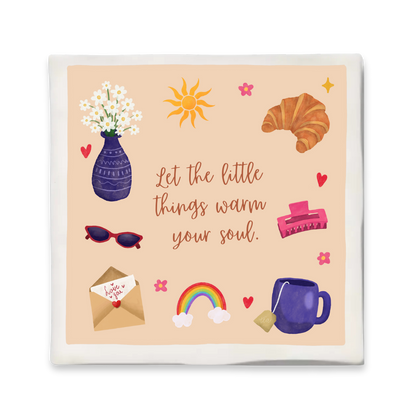 Tegeltje met de quote “Let the little things warm your soul” in het midden, omringd door kleurrijke illustraties van een paarse vaas met bloemen, zon, croissant, haarclip, rode zonnebril, liefdesbrief, regenboog en een paarse mok met theezakje. Zachte perzikkleurige achtergrond met kleine hartjes en bloemetjes.